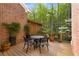 Relaxing outdoor deck area with outdoor furniture set amid lush greenery and a brick exterior at 12120 Dancliff Trce, Alpharetta, GA 30009