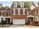 Charming brick townhome featuring a two-car garage and dormer windows at 12120 Dancliff Trce, Alpharetta, GA 30009