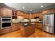 Charming kitchen with stainless steel appliances, center island, and wood cabinets at 12120 Dancliff Trce, Alpharetta, GA 30009