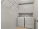 Functional laundry room with washer, dryer, and overhead cabinets at 12120 Dancliff Trce, Alpharetta, GA 30009