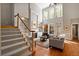Bright living room featuring fireplace, staircase, and vaulted windows at 12120 Dancliff Trce, Alpharetta, GA 30009