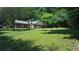 Exterior view of brick home with established trees, offering both curb appeal and shade at 1256 E Piedmont Rd, Marietta, GA 30062