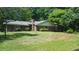 Quaint brick home with a chimney and a lush green lawn surrounded by mature trees at 1256 E Piedmont Rd, Marietta, GA 30062