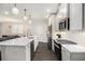 Modern kitchen showcasing sleek white cabinets, stainless steel appliances, and stylish pendant lighting at 3717 Silvery Way, Powder Springs, GA 30127