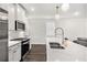 Modern kitchen showcasing stainless steel appliances, white cabinetry, and a large island for food preparation at 3717 Silvery Way, Powder Springs, GA 30127