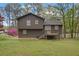 View of the back of the home with a deck and large backyard with mature landscaping at 570 Bell Se Rd, Conyers, GA 30094