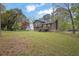 Large, grassy backyard featuring mature trees and a partial fence, offering privacy at 570 Bell Se Rd, Conyers, GA 30094