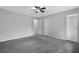 A view of a bedroom with gray carpet, white walls, a ceiling fan, and an attached bathroom at 570 Bell Se Rd, Conyers, GA 30094