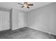A view of a bedroom with gray carpet, white walls, white doors, and a ceiling fan at 570 Bell Se Rd, Conyers, GA 30094