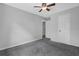 A view of a bedroom with gray walls and carpet, and a white door and ceiling fan at 570 Bell Se Rd, Conyers, GA 30094