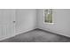 Cozy bedroom featuring a window and door, neutral walls, and plush gray carpeting at 570 Bell Se Rd, Conyers, GA 30094