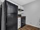 A view of the black refrigerator, stove, range hood, and white cabinets in the kitchen at 570 Bell Se Rd, Conyers, GA 30094