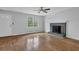 Bright living room featuring hardwood floors, a cozy fireplace, and a large window at 570 Bell Se Rd, Conyers, GA 30094
