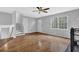 Open-concept living room with hardwood floors, stairs to the second floor, and a large window at 570 Bell Se Rd, Conyers, GA 30094