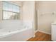 Bathroom with a jetted tub, glass shower, and wood look floor at 6028 Connaught Se Dr, Mableton, GA 30126