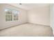 An empty carpeted bedroom with a large window, neutral walls, and white trim creates a bright, spacious atmosphere at 6028 Connaught Se Dr, Mableton, GA 30126