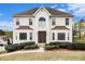 Stucco two-story home with manicured landscaping and a dark roof under a blue sky at 6028 Connaught Se Dr, Mableton, GA 30126
