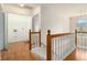Hallway with wood floors, stairs to the left and railing to the right, leading to a possible laundry room at 6028 Connaught Se Dr, Mableton, GA 30126