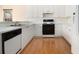 Well-lit kitchen features white appliances, wood floors, and plentiful counter space at 6028 Connaught Se Dr, Mableton, GA 30126