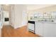 Cozy kitchen with white cabinets, stainless sink, black dishwasher and hardwood floors leading to the living room at 6028 Connaught Se Dr, Mableton, GA 30126