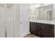 Bathroom featuring double sinks, a shower, and dark wood-grain cabinets at 6625 Story Cir, Norcross, GA 30093