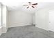 Spacious bedroom featuring neutral walls, ceiling fan, plush gray carpet, and natural light at 6625 Story Cir, Norcross, GA 30093