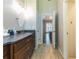 Well-lit bathroom with a dark wood vanity, tile flooring, and a view into the main bedroom at 1630 Chadwick Mill Ln, Lawrenceville, GA 30043