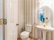 Powder room with pedestal sink and decorative wallpaper at 1630 Chadwick Mill Ln, Lawrenceville, GA 30043