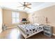 Comfortable bedroom featuring hardwood floors, a ceiling fan, and a bright window at 1630 Chadwick Mill Ln, Lawrenceville, GA 30043