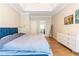 Spacious main bedroom featuring tray ceiling, sleek dresser, and a comfortable blue bed at 1630 Chadwick Mill Ln, Lawrenceville, GA 30043
