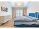 Serene main bedroom showcasing tray ceiling, modern dresser, shuttered windows, and a plush blue bed at 1630 Chadwick Mill Ln, Lawrenceville, GA 30043
