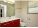Well-lit bathroom featuring a red vanity, mirror, sink, toilet, window with blinds, and towel bar at 310 Brittany Ct, Duluth, GA 30096