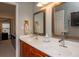 Bright bathroom featuring double sinks, wood cabinets, large mirrors, and access to an adjacent room at 310 Brittany Ct, Duluth, GA 30096