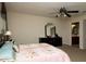 Bedroom featuring soft carpet, ceiling fan, dresser with mirror, queen bed, and view of the ensuite bathroom at 310 Brittany Ct, Duluth, GA 30096