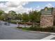 Community entrance sign surrounded by landscaping and mature trees under a cloudy sky at 310 Brittany Ct, Duluth, GA 30096