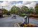 Gated community entrance with iron gates, landscaping, and a cloudy sky above at 310 Brittany Ct, Duluth, GA 30096