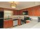 Kitchen featuring wood cabinets, gray countertops, black appliances, and a stainless steel dishwasher at 310 Brittany Ct, Duluth, GA 30096