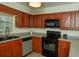 Well-lit kitchen with wood cabinets, black appliances, and gray countertops with a window for natural light at 310 Brittany Ct, Duluth, GA 30096