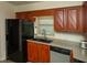Bright kitchen showcasing wood cabinets, stainless steel dishwasher, granite countertops, and a modern black refrigerator at 310 Brittany Ct, Duluth, GA 30096