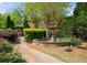 Stone fountain surrounded by lush green landscaping with a gazebo and red brick home in the background at 310 Brittany Ct, Duluth, GA 30096