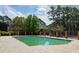 Community swimming pool surrounded by a concrete pool deck and mature trees under a cloudy sky at 310 Brittany Ct, Duluth, GA 30096