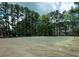 Community tennis court surrounded by mature trees with buildings and parking in the background at 310 Brittany Ct, Duluth, GA 30096