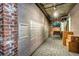 Hallway leading to mail room with exposed brick walls and brick-look porcelain tile flooring at 3235 Roswell Ne Rd # 508, Atlanta, GA 30305