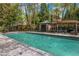 A swimming pool surrounded by mature trees, lounge chairs, and a covered grilling area at 3235 Roswell Ne Rd # 508, Atlanta, GA 30305