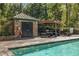 Community pool area features a pool house, outdoor seating, a pergola, and mature trees at 3235 Roswell Ne Rd # 508, Atlanta, GA 30305
