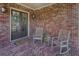 Covered front porch with rocking chairs and stylish brick flooring at 314 Lakeside Trce, Canton, GA 30115