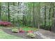 Landscaped backyard with flower beds, mature trees and stone accents at 4950 Willow Creek Dr, Woodstock, GA 30188