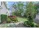 A lush backyard with a deck, landscaped garden beds, and mature trees at 4950 Willow Creek Dr, Woodstock, GA 30188