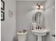 Charming half bathroom featuring a pedestal sink, decorative mirror, and soft neutral paint at 4950 Willow Creek Dr, Woodstock, GA 30188