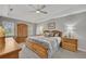 Bright primary bedroom with wood furniture, ceiling fan, and windows for natural light at 4950 Willow Creek Dr, Woodstock, GA 30188